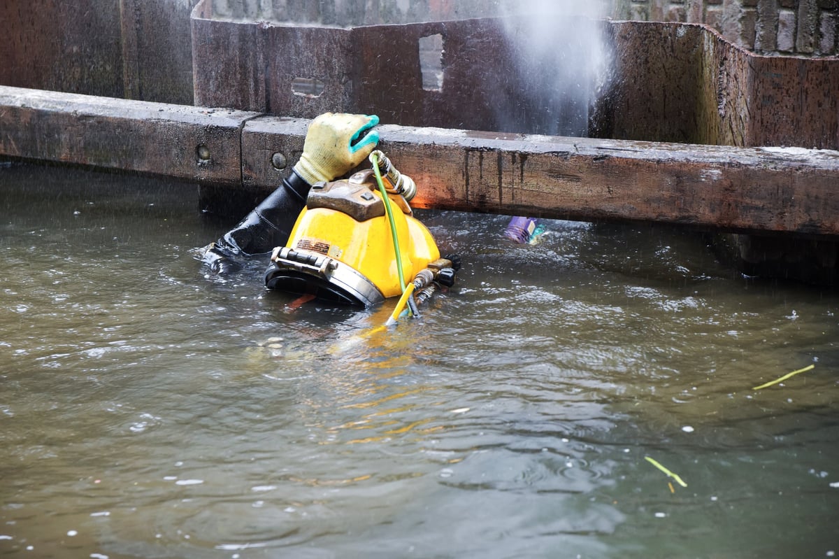 Commercial diver in a yellow helmet working underwater